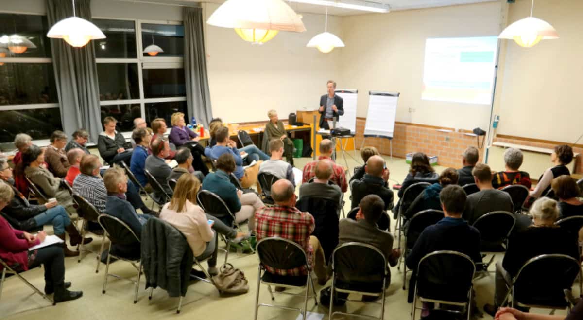 Bewoners luisteren naar presentatie