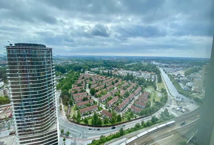 Huurders Ymere Amsterdam, uitzicht op woonwijk en skyline onder bewolkte hemel.
