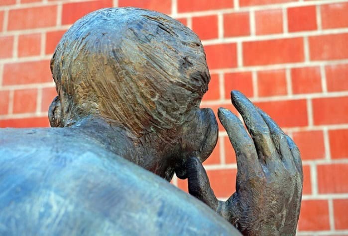 Huurders Ymere Amsterdam beeld van een bronzen standbeeld met een brick muur achtergrond.
