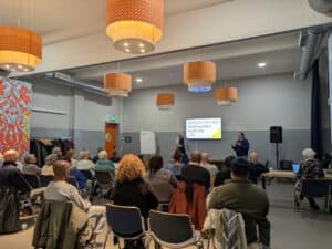 Huurders Ymere Amsterdam tijdens een bijeenkomst in een moderne zaal.